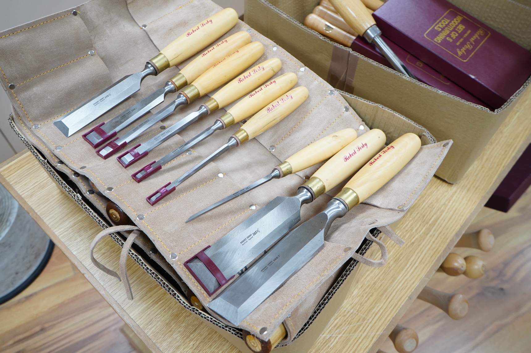 Five woodworking chisel sets, all in leather rolls, including an unused nine piece set by Robert Sorby, a six piece set by Henry Taylor, and three other sets showing some wear